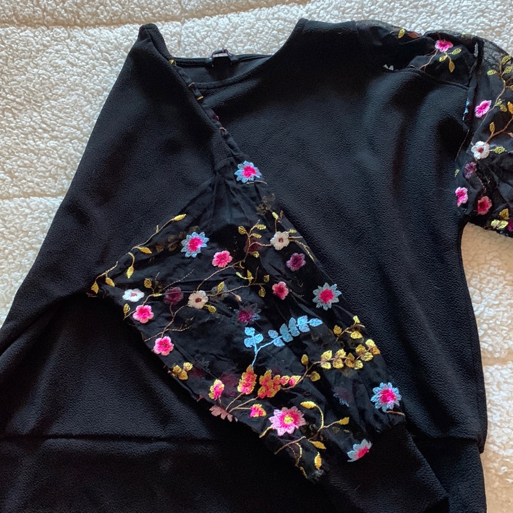 A medium sized shirt. Black with a flower lace sleeve.